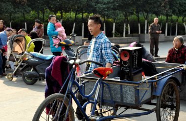 Pengzhou, China: Man with Boom Box in Bicycle Cart clipart