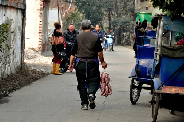 Pengzhou, China: Homem com pacote de salsichas — Fotografia de Stock