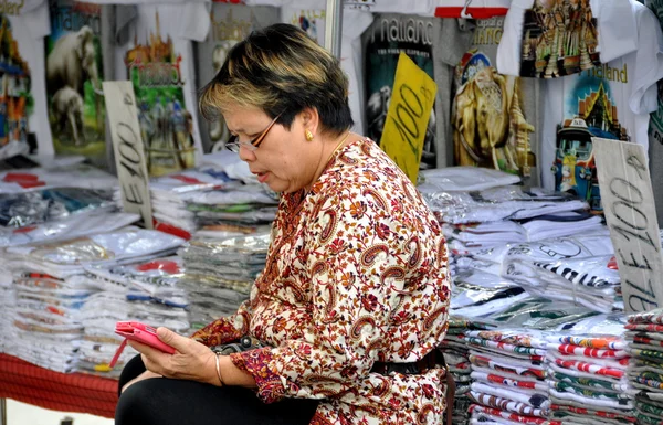Бангкок, Таиланд: женщина на рынке чистит сотовый телефон — стоковое фото