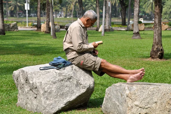 Bangkok, Tailandia: Hombre leyendo en Lumphini Park — Foto de Stock