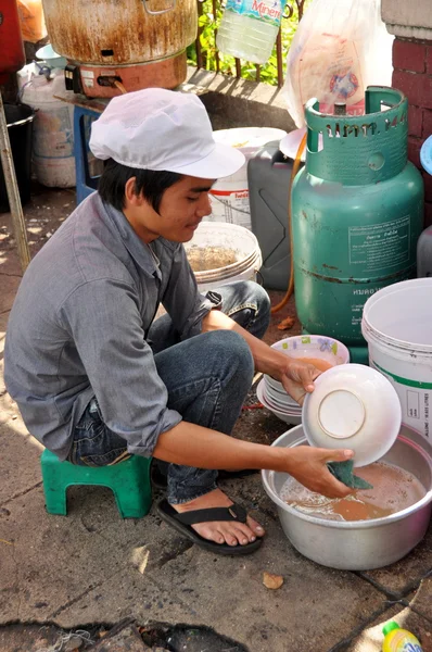 Bangkok, Thailand: Man Washing Dishes on Sidewalk