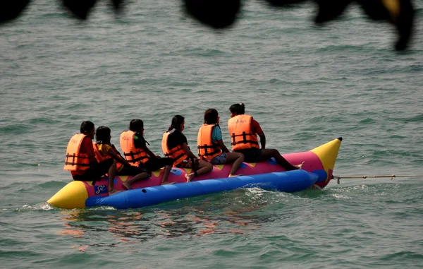 Pattaya, Tailândia: Pessoas montando um barco de banana — Fotografia de Stock