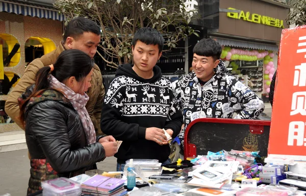 Pengzhou, China: Los adolescentes que venden las cubiertas del teléfono celular —  Fotos de Stock