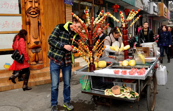 Pengzhou, China: Hombre que compra palillo de fruta vidriada —  Fotos de Stock