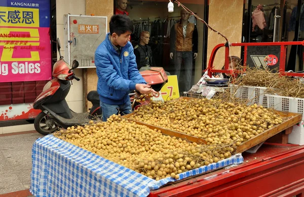 Pengzhou, Kina: man som säljer longan frukter — Stockfoto