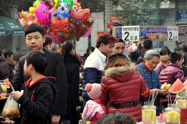 Pengzhou, China: Menschen und Lebensmittelhändler im Stadtpark — Stockfoto