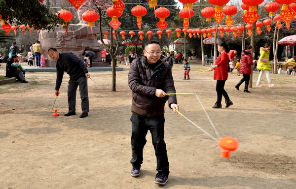 Pengzhou, china: Mann dreht Ti Huang Kreisel im Stadtpark — Stockfoto