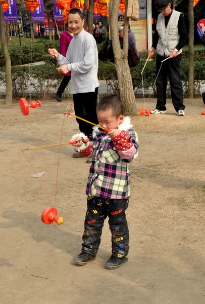 Pengzhou, china: kleiner Junge dreht ti huang top — Stockfoto