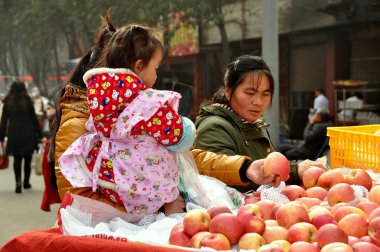 Pengzhou, China: Mother with Baby Buying Apples clipart
