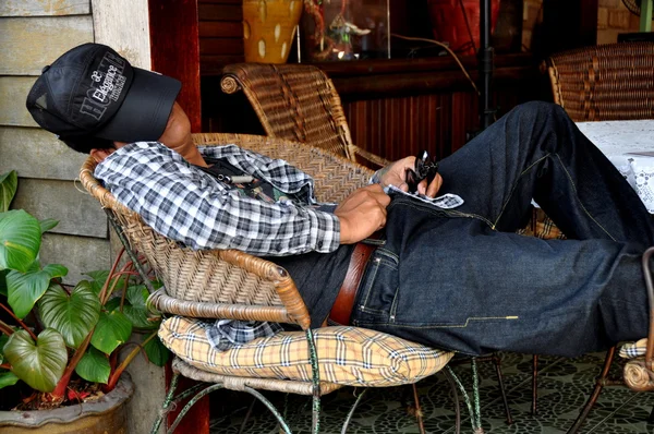 Pattaya, thailand: thai man framöver i wicker stol — Stockfoto