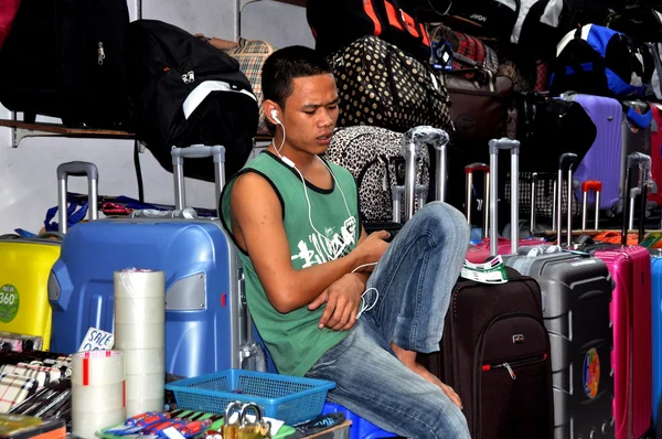 Pattaya, Tailandia: Jóvenes escuchando música en la tienda de equipajes —  Fotos de Stock