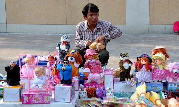 Pattaya, Tailandia: Hombre vendiendo muñecas y juguetes para niños —  Fotos de Stock