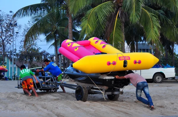 Bang Saen, Thaïlande : Les hommes poussent le chariot avec bateau sur la plage — Photo