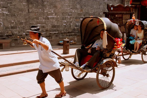 Luo Dai, Kina: Mand trækker Rickshaw - Stock-foto