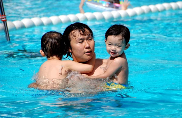 Batu Ferringhi, Malasia: Padre con hijos en la piscina — Foto de Stock