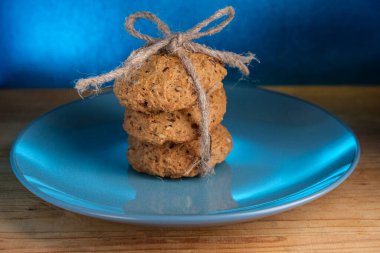 Mavi tabakta zencefilli kurabiyelerle dolu bir hayat. Yulaf kekleri keten iplikle örülmüş..