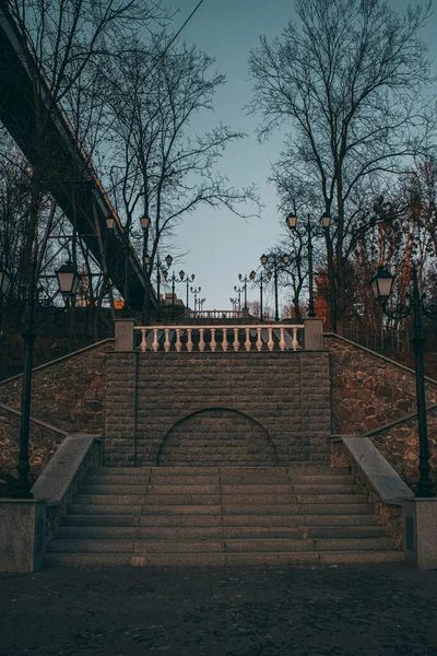 Park area with a stone arch and steps along the slope. — Stok fotoğraf