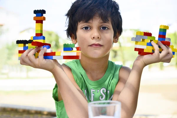 Niño sosteniendo artesanías creadas a partir de ladrillos de colores — Foto de Stock