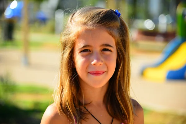 Hermosa chica rubia de pelo jugando en el patio de recreo — Foto de Stock