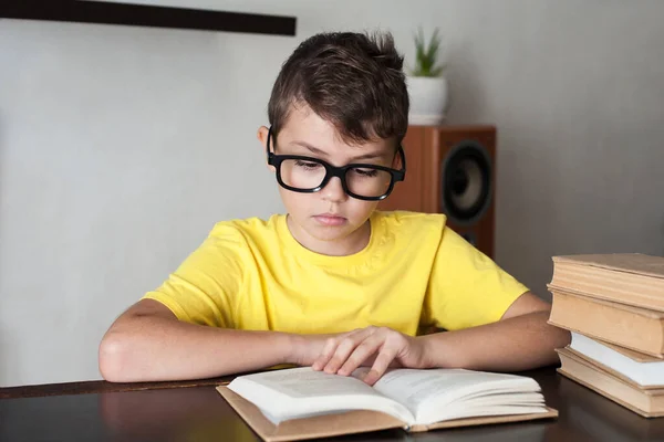 Ein Junge Mit Brille Und Gelbem Shirt Liest Hause Tisch — Stockfoto