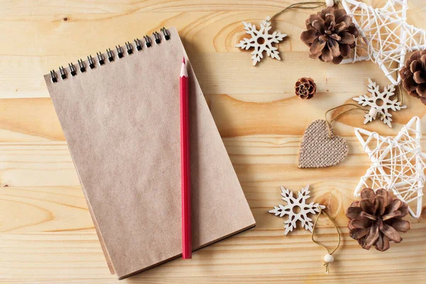 Bir el işi defteri ve ahşap bir arka planda kırmızı bir kalem. Noel Baba 'ya mektup