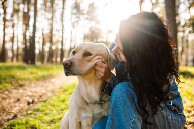 Labradorlu bir kız. Köpek gülümsüyor. Komik ağızlık. Ormanda av köpeği olan genç bir kadın.