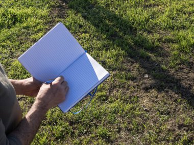 Olgun çiftçi tarladaki bir deftere not alıyor. Tarım kavramı.