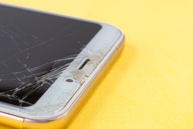 Birçok çatlağı olan modern bir akıllı telefonun kırık ekranının makro görüntüsü.