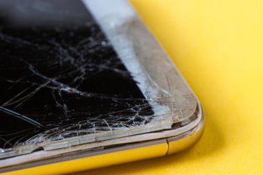 Birçok çatlağı olan modern bir akıllı telefonun kırık ekranının makro görüntüsü.