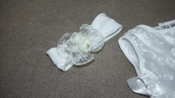 Clothes for the little princess. White dress and headband with beautiful flowers — Stock Video