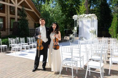 Düğün kemeri geçmişi olan kadın ve erkek kemancılar.