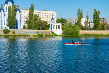 Sporcular güneşli bir yaz gününde kanolarla nehirde yüzerler..