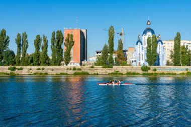 Athletes swim in the river in kayaks on a summer sunny day.