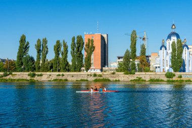 Sporcular güneşli bir yaz gününde kanolarla nehirde yüzerler..