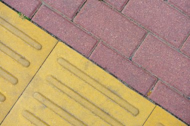 Çapraz eklemli kırmızı ve sarı kaldırım levhaları.