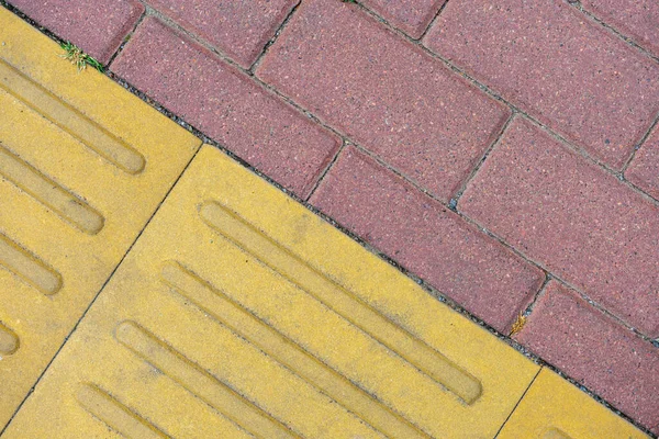 Çapraz eklemli kırmızı ve sarı kaldırım levhaları.