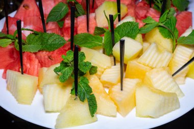 Tabak dilimlenmiş ve kavun ve karpuzla süslenmiş..