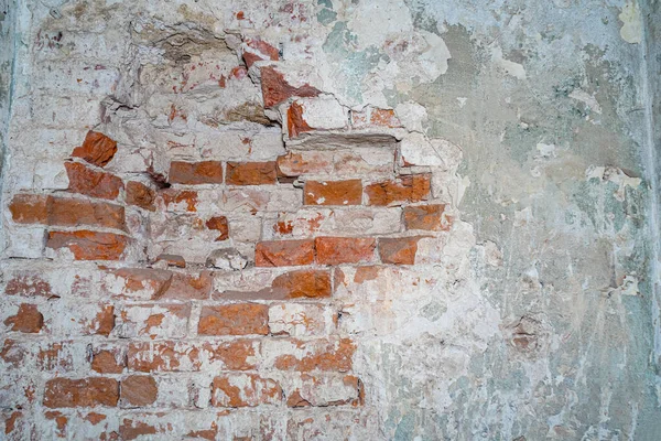 Eski bir kırmızı tuğla binadaki yıkılmış duvar..
