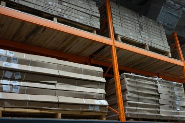 Bir sürü karton kutusu olan büyük sarı bir raf..