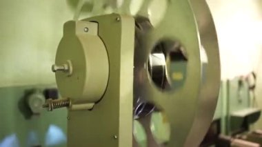 A vintage reel from a movie projector spins during a movie screening in a movie theater