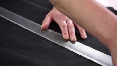 The seamstress marks the pattern on the material