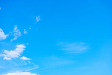 Mavi bir arkaplanda birkaç küçük beyaz bulut.