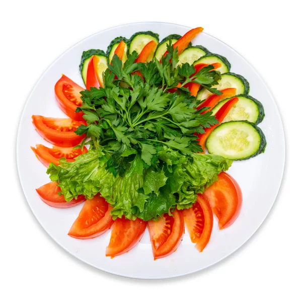 Sliced tomatoes, cucumbers, red pepper and garnished with parsley and lettuce. Fresh Vegetables Plate. Isolate.