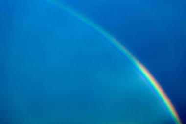 A rainbow on the background of a dark blue sky. Horizontal photo