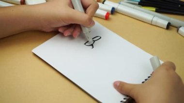 The student writes with her left hand in a notebook. Back to school
