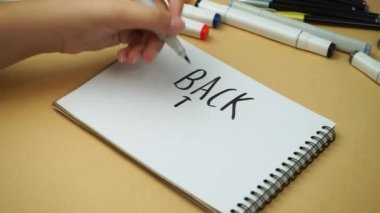 Back to school, the girl wrote in a notebook with a black marker
