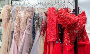 Multicolored wedding and evening dresses on a rack in a bridal shop.