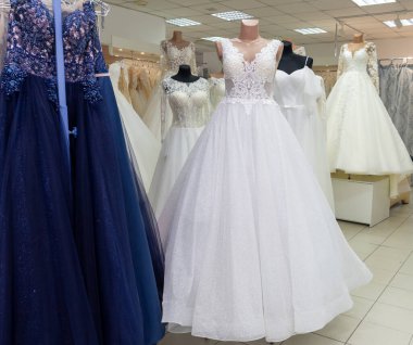 Many different wedding dresses in the bridal shop.