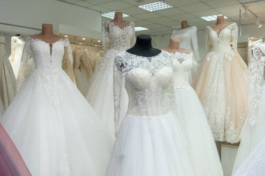 Many different wedding dresses in the bridal shop. Clous up