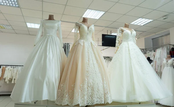 Three chic wedding dresses on mannequins. Three different models of beautiful wedding dresses.